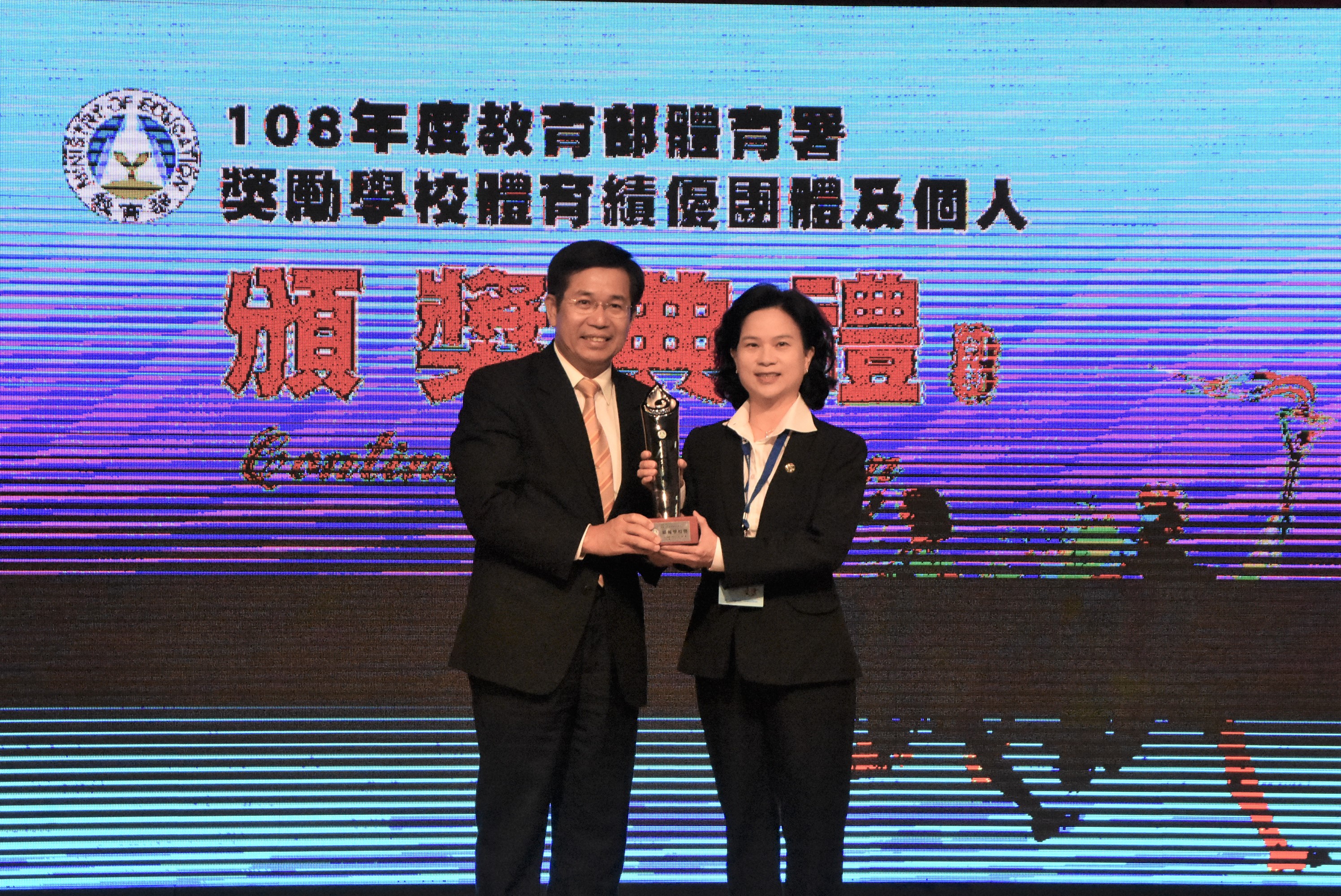 Minister of Education Dr. Wen-Chung Pan (left) presents Excellent Performance Award to Director Shu-Chen Huang (right)